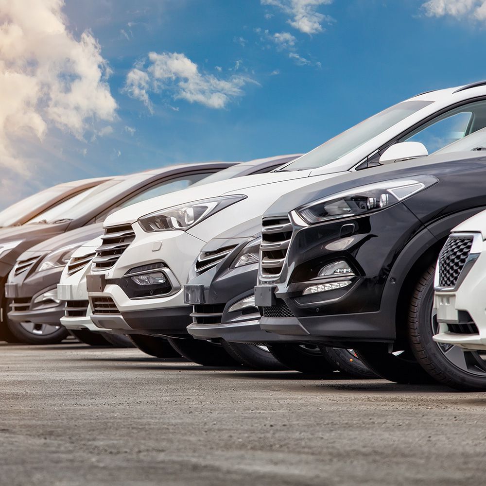 Eine Reihe von geparkten Autos in verschiedenen Farben, die unter einem strahlend blauen Himmel ein elegantes Design aufweisen.